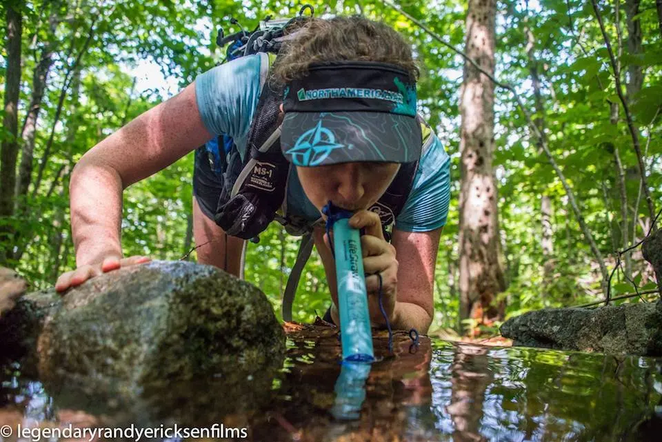 Kate taking a sip from the stream